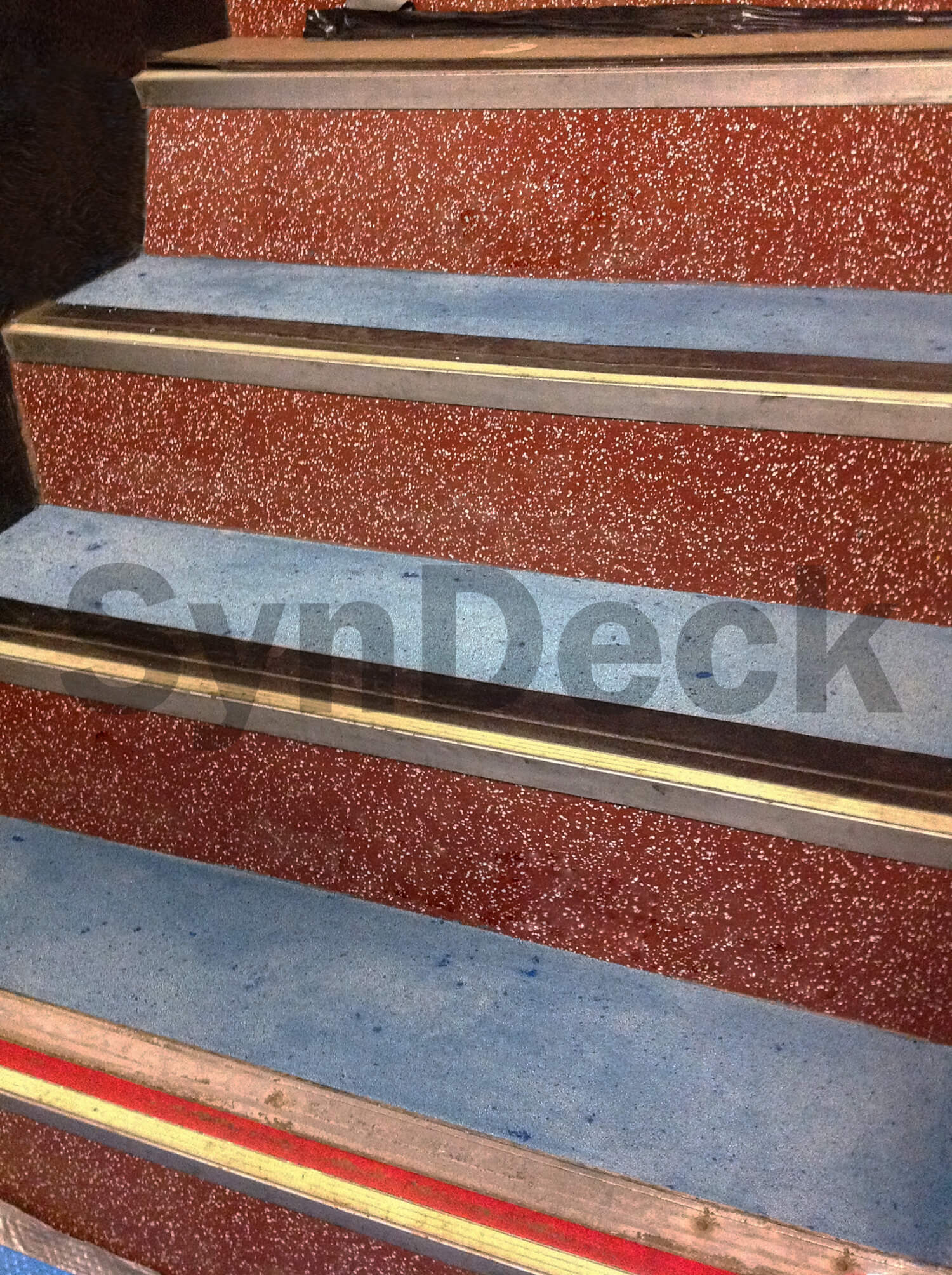 Image of In Progress SynDeck Epoxy System with Flake in Red, showing Bond Coat with Underlayment on Ferry Stairs